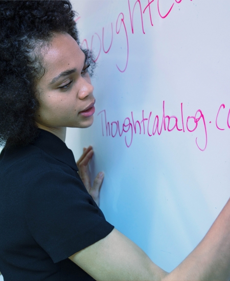 A woman writing on a white board